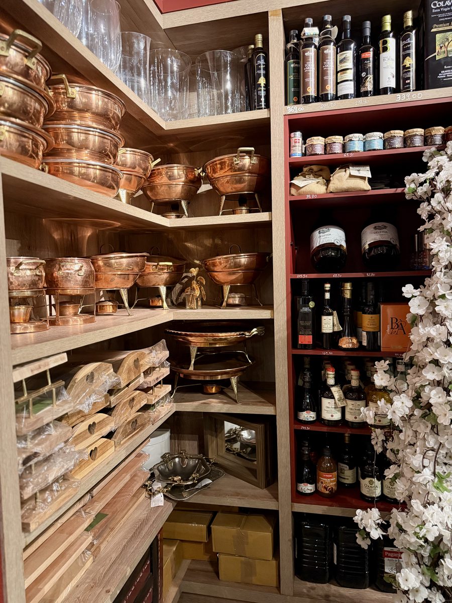 Empório com panelas de cobre, vinhos e azeites importados