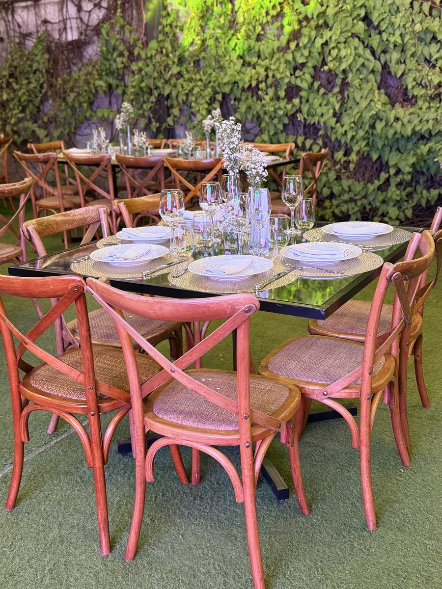 Mesa decorada com cadeiras rosa em jardim verde